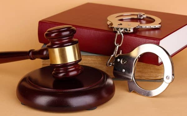 Gavel, Handcuffs And Book On Law On Beige Background