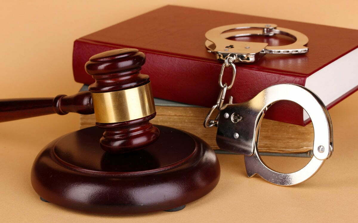 Gavel, Handcuffs And Book On Law On Beige Background