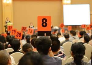 People Holding Auction Paddle To Buy From Auction.